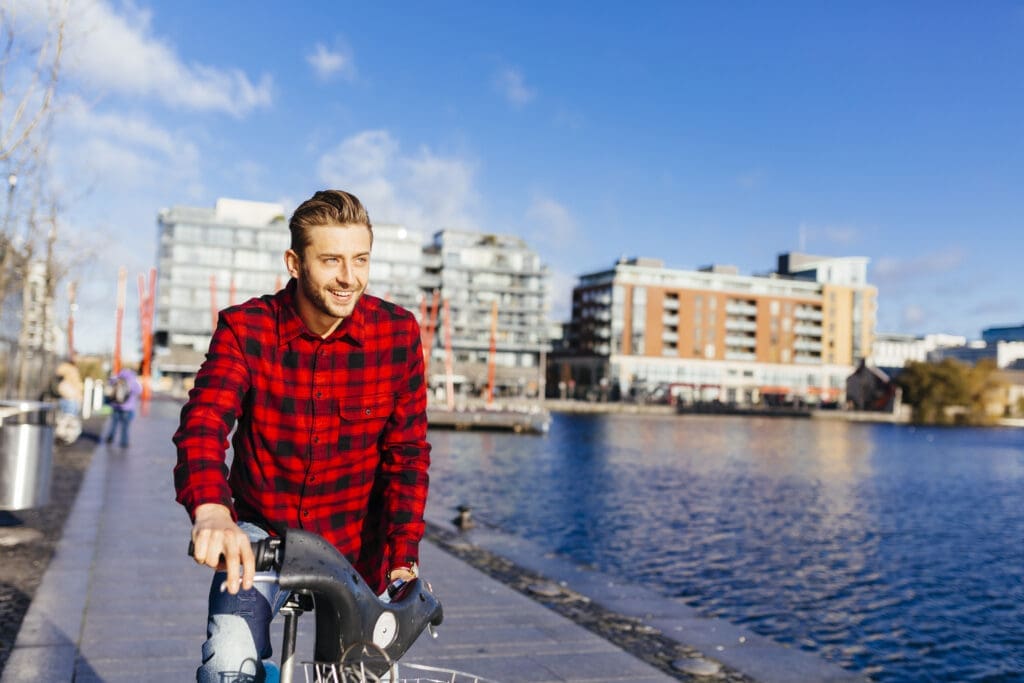 Ireland, Dublin, young man at city dock with city bike
